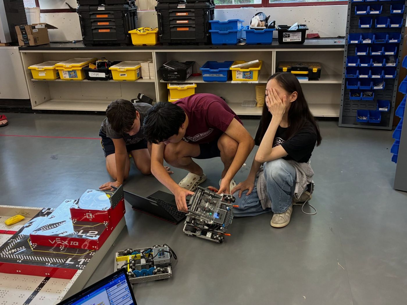 Team members helping campers troubleshoot a VEX IQ robot