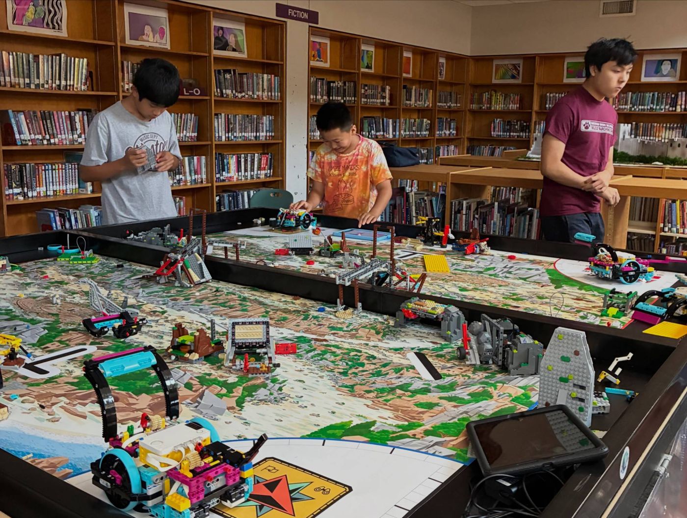 GNCE Mercury members coaching young students at an FLL table